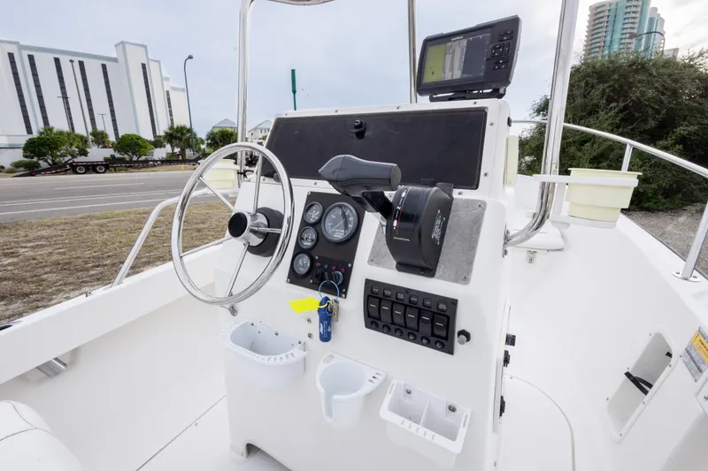 Slide: The Image of 1999 Boston Whaler Outrage 17 boat console with steering wheel and navigation equipment. - 27