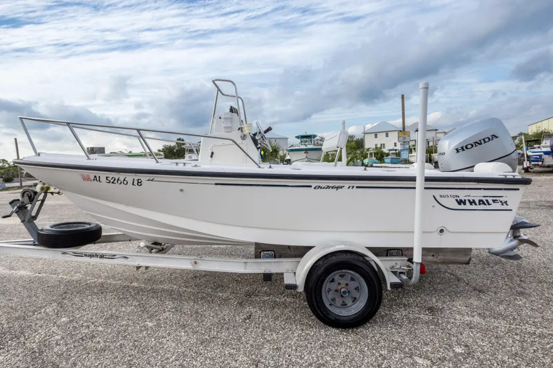 Slide: The Image of 1999 Boston Whaler Outrage 17 boat on trailer, featuring Honda outboard motor. - 9