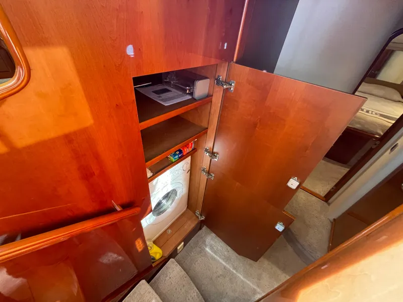 Slide: The Image of 2005 Viking Princess 50 Flybridge interior with wooden cabinetry and built-in washing machine. - 17