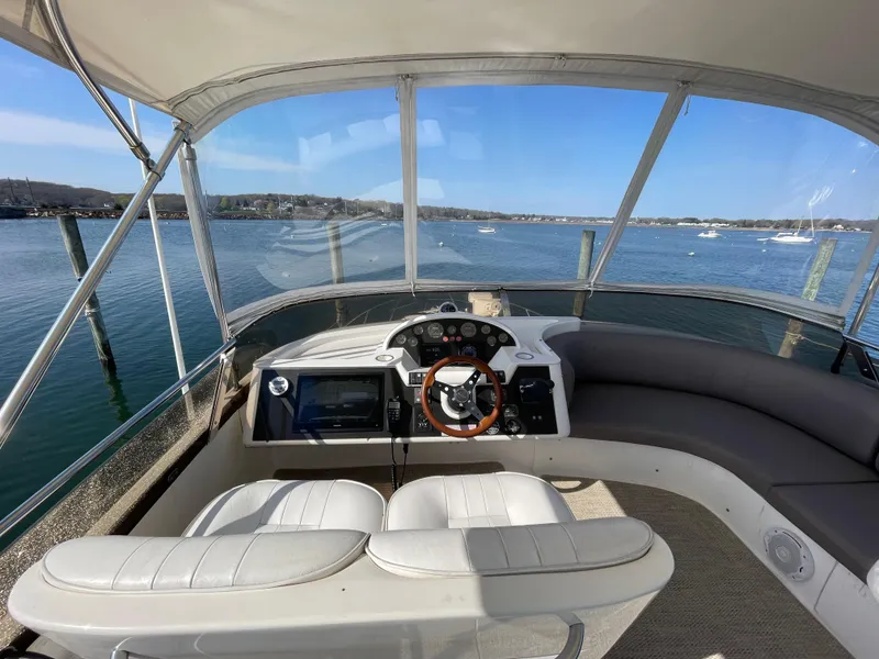 Slide: The Image of Flybridge of 2005 Viking Princess 50, featuring helm and seating, overlooking serene waters. - 29