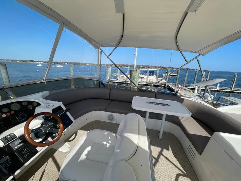 Slide: The Image of Flybridge of 2005 Viking Princess 50, featuring helm, seating, and table with ocean view. - 31