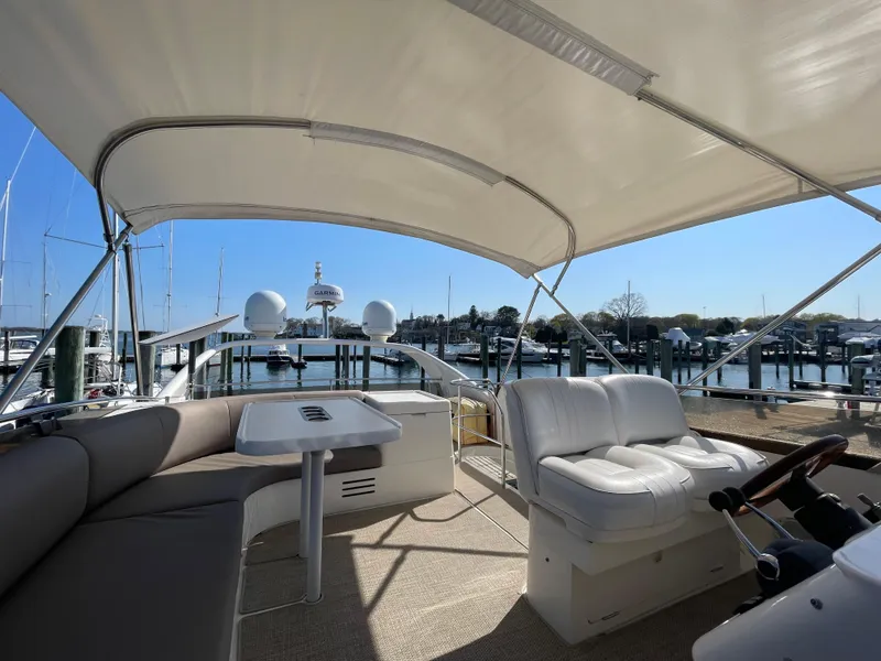 Slide: The Image of Flybridge of 2005 Viking Princess 50, featuring seating and helm, docked at marina. - 32