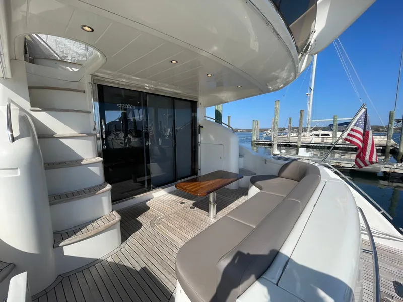Slide: The Image of 2005 Viking Princess 50 Flybridge yacht with seating, table, and American flag at marina. - 4