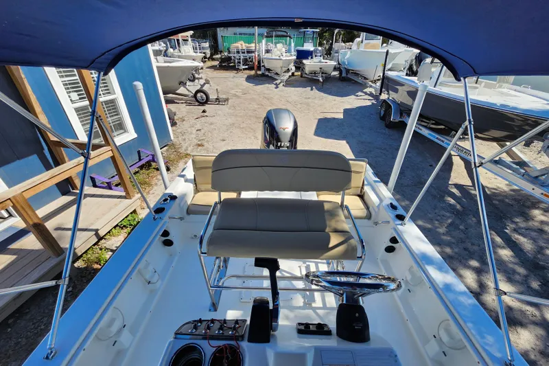 Slide: The Image of 2020 NauticStar 195 NauticBay boat interior with steering wheel and seating under canopy. - 22
