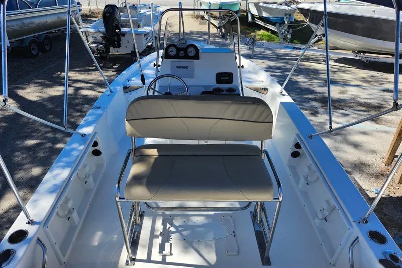 Slide: The Image of 2020 NauticStar 195 NauticBay boat interior with seating and console, parked outdoors. - 27
