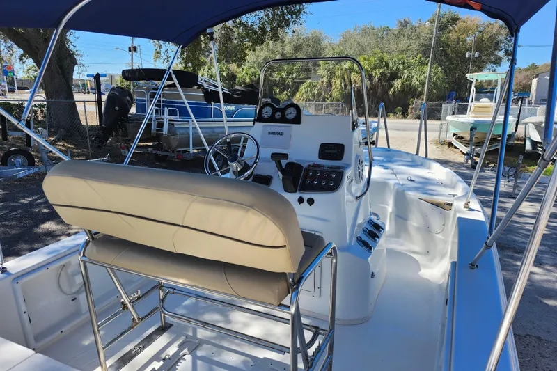 Slide: The Image of 2020 NauticStar 195 NauticBay boat interior with steering console and seating under canopy. - 30