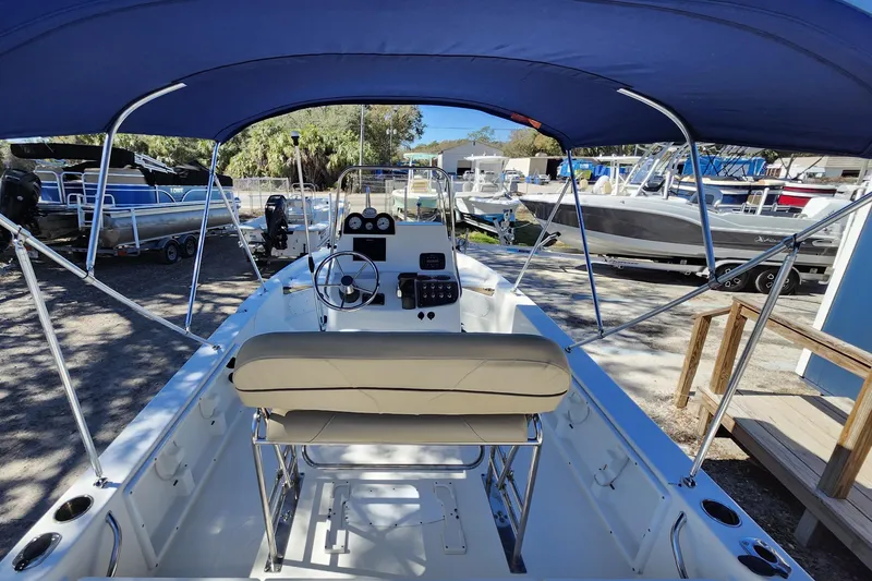 Slide: The Image of 2020 NauticStar 195 NauticBay boat interior with blue canopy and steering console. - 34