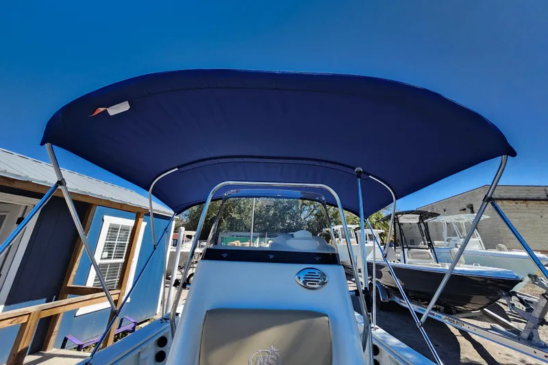 Slide: The Image of 2020 NauticStar 195 NauticBay boat with blue canopy, docked under clear sky. - 35