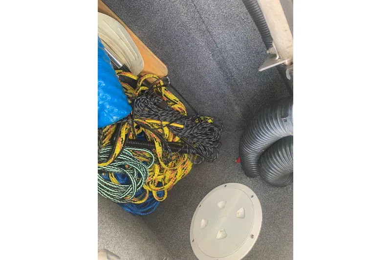 Slide: The Image of Storage compartment of a 2004 Yamaha AR230 boat with ropes and ventilation hoses. - 23