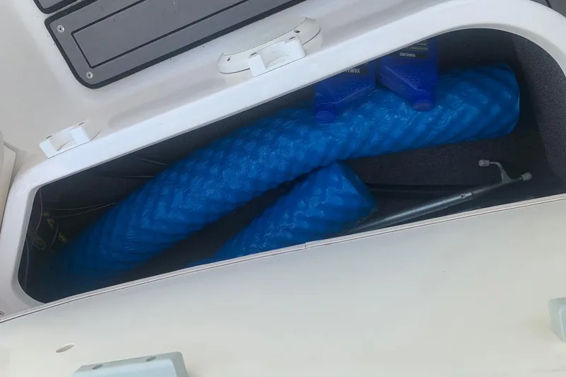 Slide: The Image of Storage compartment of 2004 Yamaha AR230 boat with blue fenders and oil containers. - 25