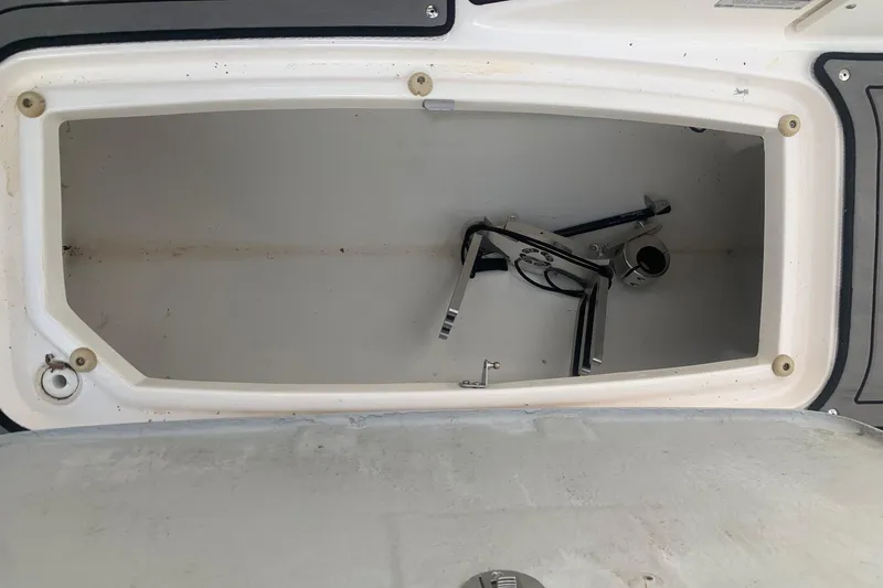 Slide: The Image of Storage compartment of a 2004 Yamaha AR230 boat, showing interior space and metal parts. - 26