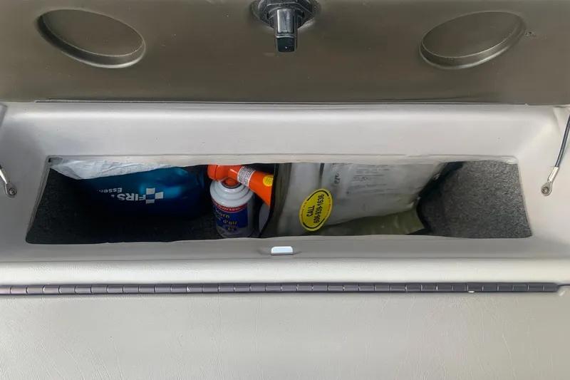 Slide: The Image of Storage compartment in a 2004 Yamaha AR230 boat, containing safety and maintenance items. - 27