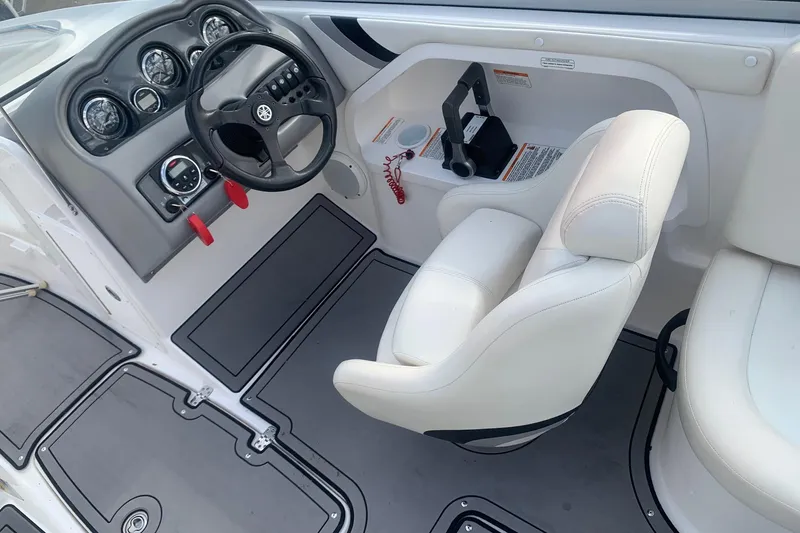 Slide: The Image of 2004 Yamaha Boats AR230 cockpit with steering wheel and white captain's chair. - 8