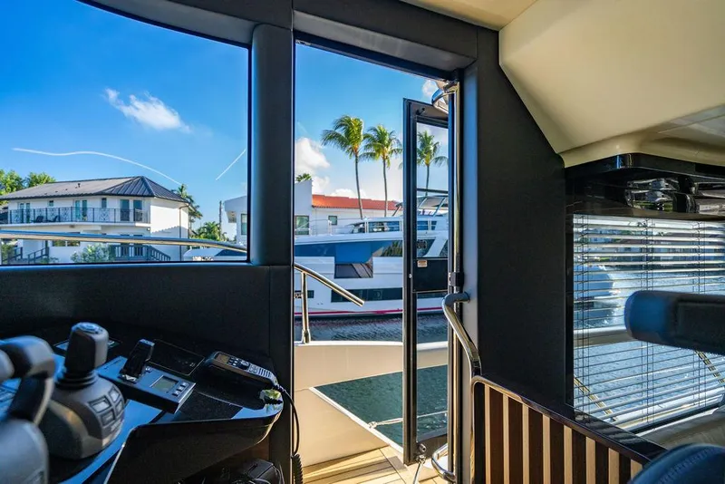 Slide: The Image of Interior view of 2023 Absolute 64 Navetta yacht with open door and waterfront scenery. - 23