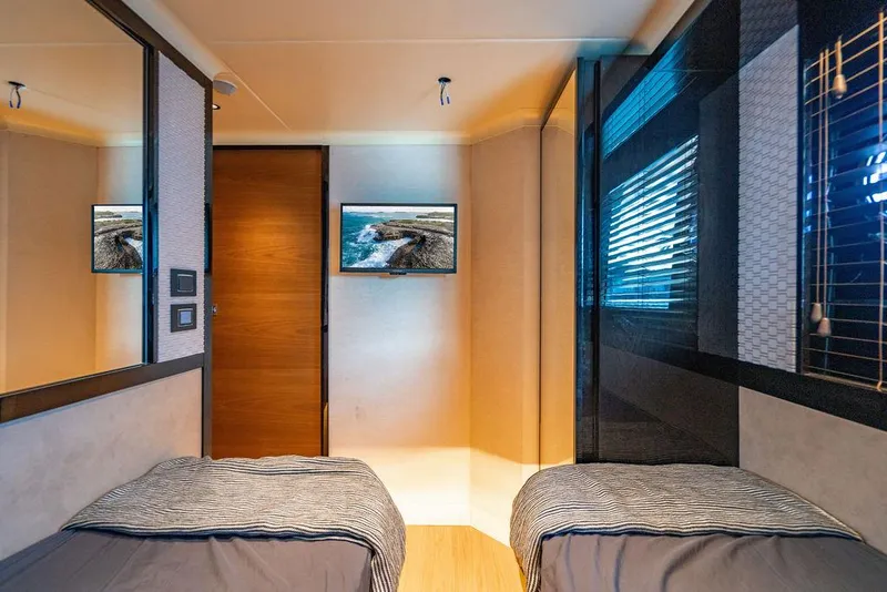 Slide: The Image of Luxurious twin bedroom on 2023 Absolute 64 Navetta yacht, featuring modern decor and TV. - 38
