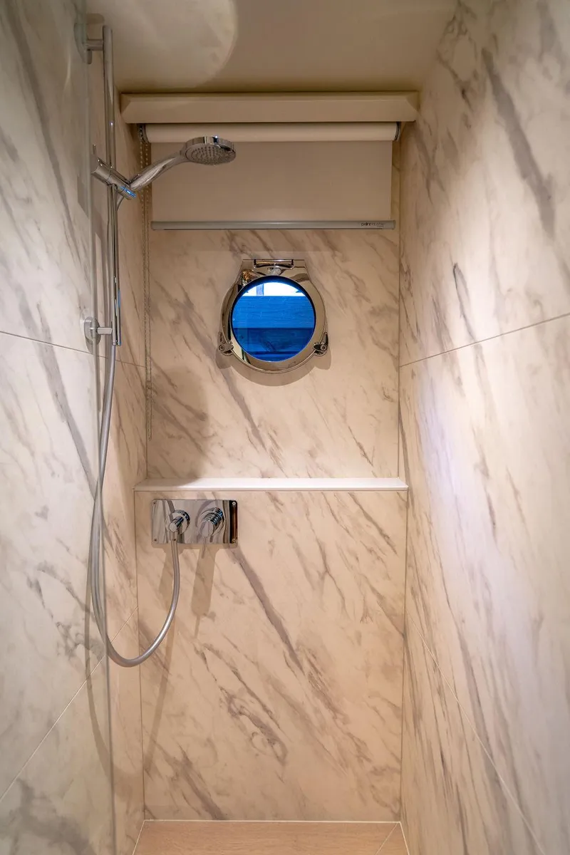 Slide: The Image of Luxurious marble shower in 2023 Absolute 64 Navetta yacht with porthole view. - 44