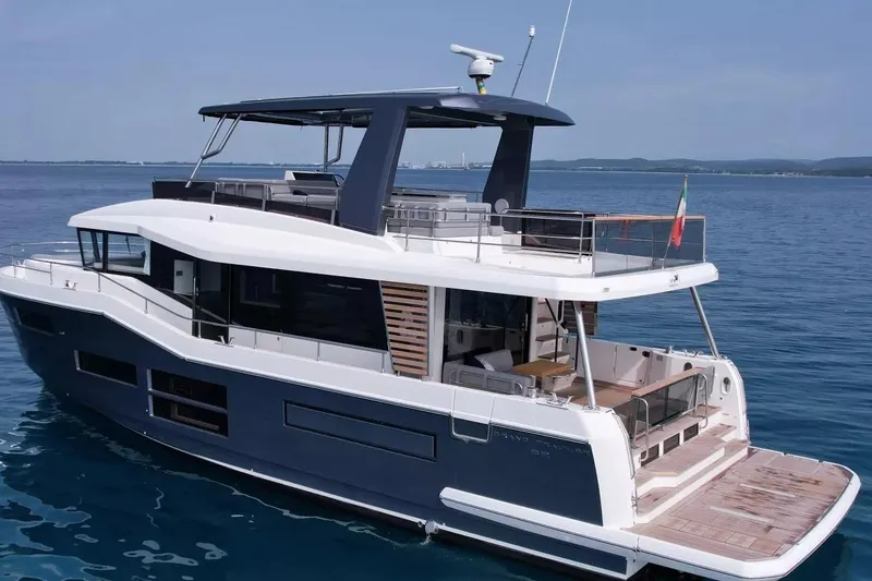 The Image of 2026 Beneteau Grand Trawler 62 yacht on calm blue sea, rear view. - 0