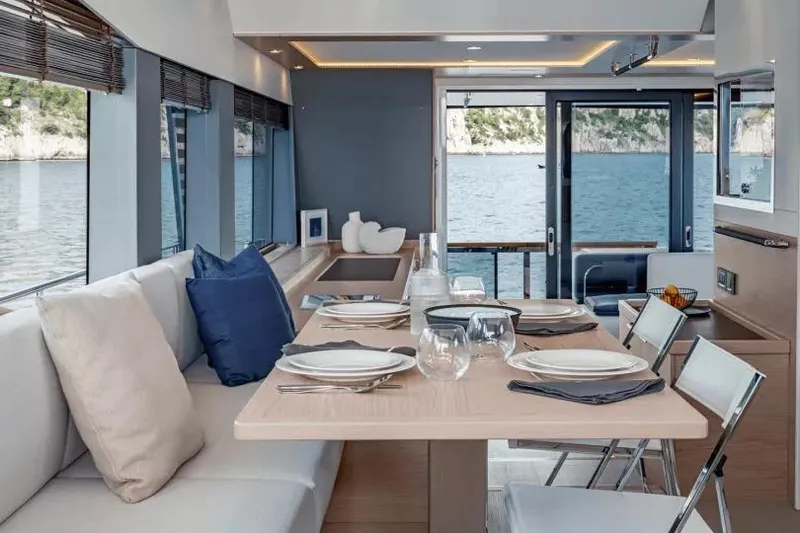 Slide: The Image of Luxurious interior of 2026 Beneteau Grand Trawler 62 with elegant dining setup and sea view. - 4