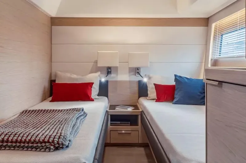 Slide: The Image of Luxurious twin cabin in 2026 Beneteau Grand Trawler 62 yacht, featuring modern decor and cozy bedding. - 8