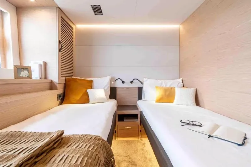 Slide: The Image of Luxurious twin cabin interior of 2026 Beneteau Grand Trawler 62 yacht, featuring modern design. - 9