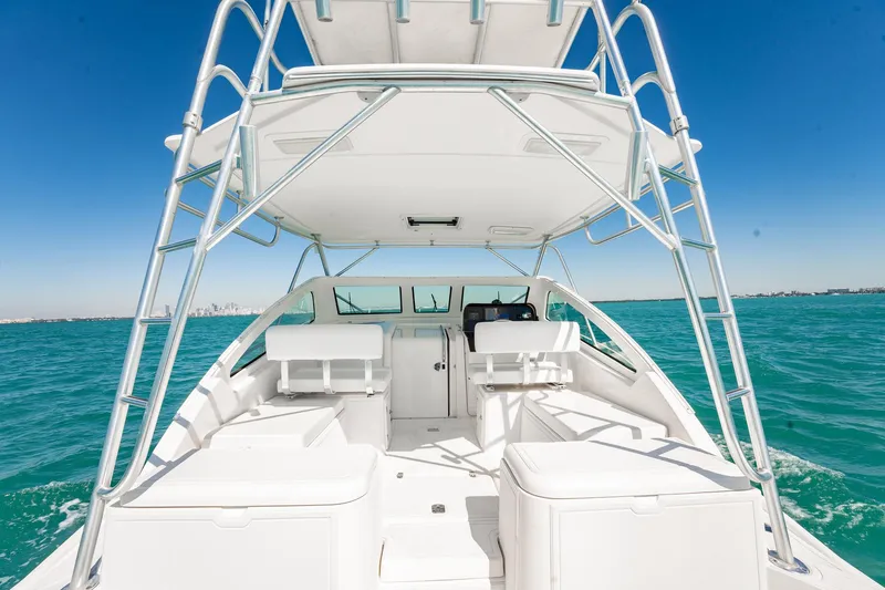 Slide: The Image of 2004 Luhrs 32 Open boat on clear blue water, showcasing spacious deck and seating. - 15