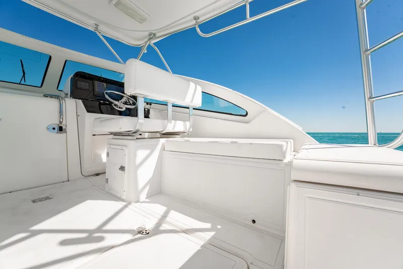 Slide: The Image of 2004 Luhrs 32 Open boat interior with helm, white seating, and ocean view. - 16