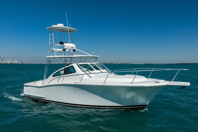 Slide: The Image of 2004 Luhrs 32 Open boat cruising on clear blue water under a sunny sky. - 2