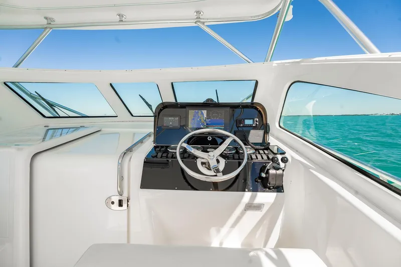 Slide: The Image of 2004 Luhrs 32 Open boat helm with navigation equipment, steering wheel, and ocean view. - 22