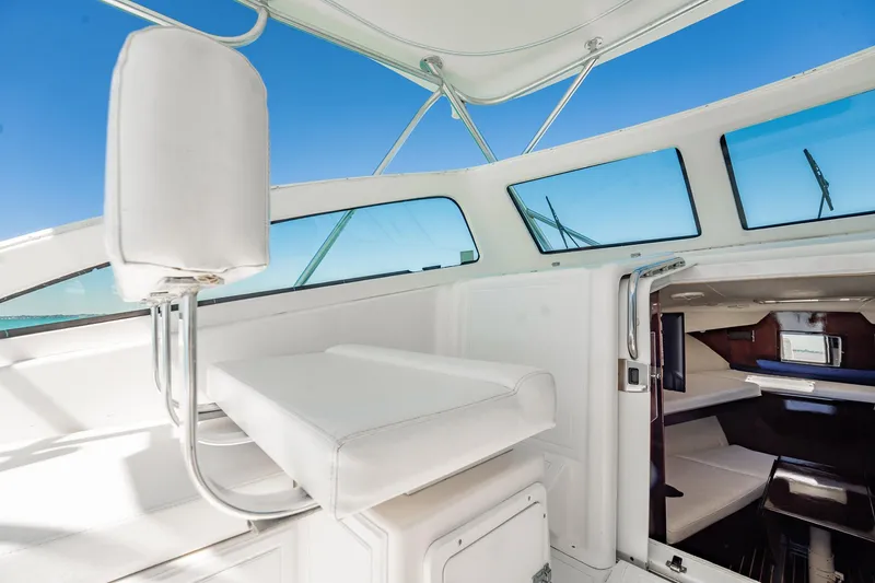 Slide: The Image of 2004 Luhrs 32 Open boat interior with white seating and cabin view. - 26