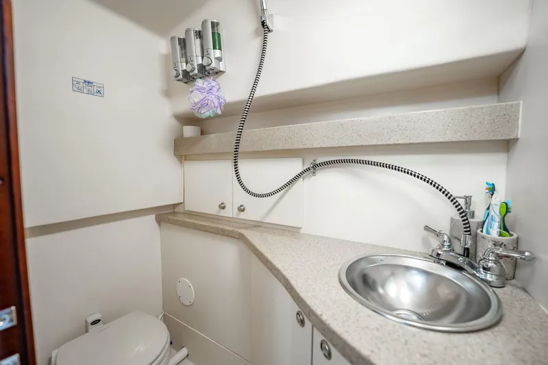 Slide: The Image of 2004 Luhrs 32 Open boat bathroom with sink, faucet, and toiletries. - 32