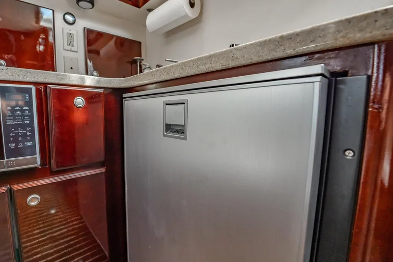 Slide: The Image of 2004 Luhrs 32 Open yacht kitchen with stainless steel fridge and wooden cabinetry. - 39