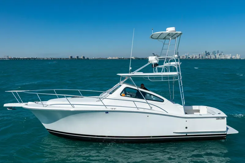 Slide: The Image of 2004 Luhrs 32 Open yacht on blue ocean with city skyline in background. - 5