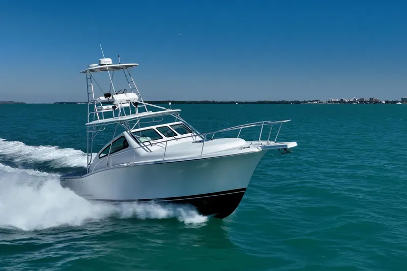 Slide: The Image of 2004 Luhrs 32 Open boat cruising on clear blue water under a sunny sky. - 60