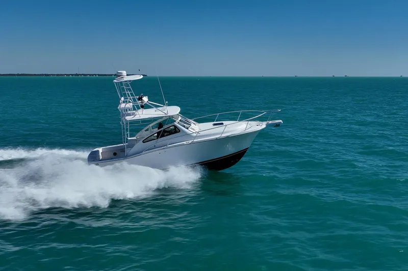 Slide: The Image of 2004 Luhrs 32 Open boat cruising on clear blue ocean waters. - 64