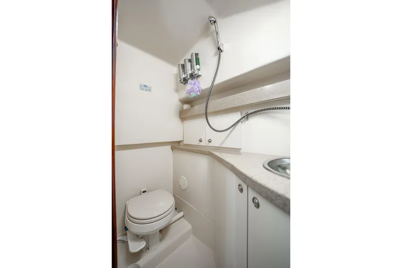 Slide: The Image of 2004 Luhrs 32 Open boat bathroom with shower, sink, and toilet. - 82