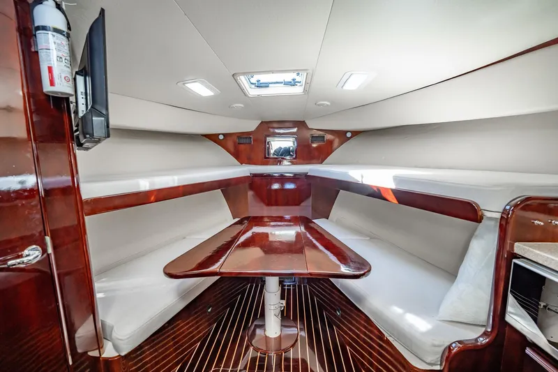 Slide: The Image of 2004 Luhrs 32 Open cabin interior with wood finish and seating area. - 84