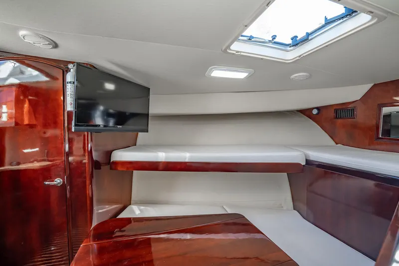 Slide: The Image of 2004 Luhrs 32 Open cabin interior with wood finish, TV, and skylight. - 89