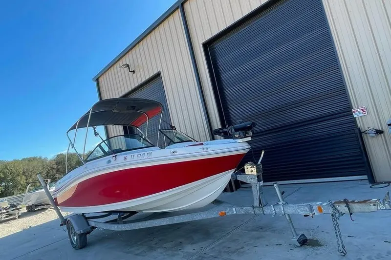 Slide: The Image of 2018 Tahoe 500 TF boat on trailer outside a large garage. - 2
