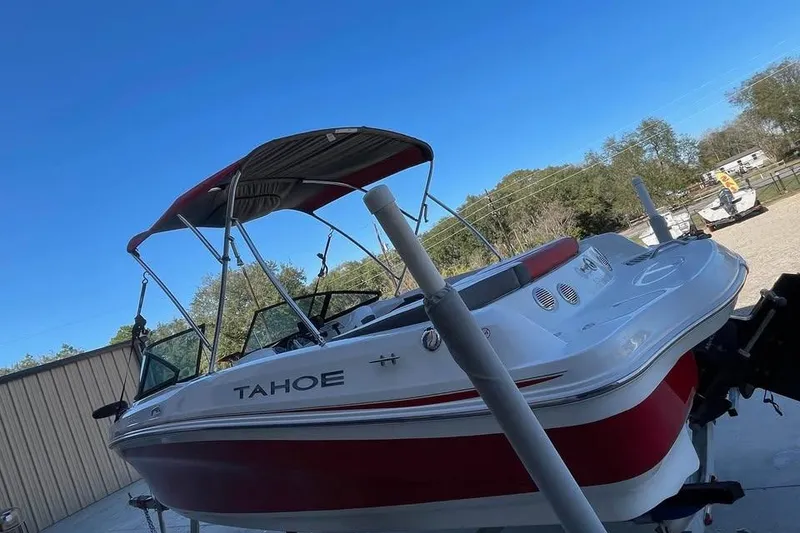 Slide: The Image of 2018 Tahoe 500 TF boat with red and white design, parked outdoors under clear blue sky. - 4