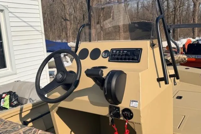 Slide: The Image of 2026 Crestliner 1760 Retriever Jon boat console with steering wheel and controls. - 5