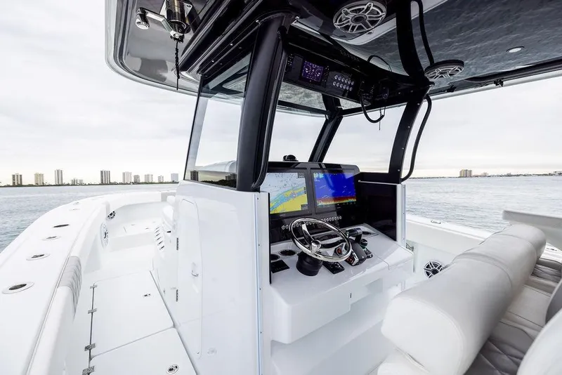 Slide: The Image of 2025 Freeman 38 boat cockpit with advanced navigation system, steering wheel, and ocean view. - 14