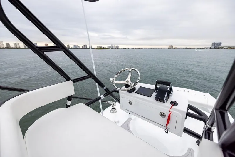 Slide: The Image of 2025 Freeman 38 boat helm with steering wheel, overlooking calm waters and city skyline. - 28