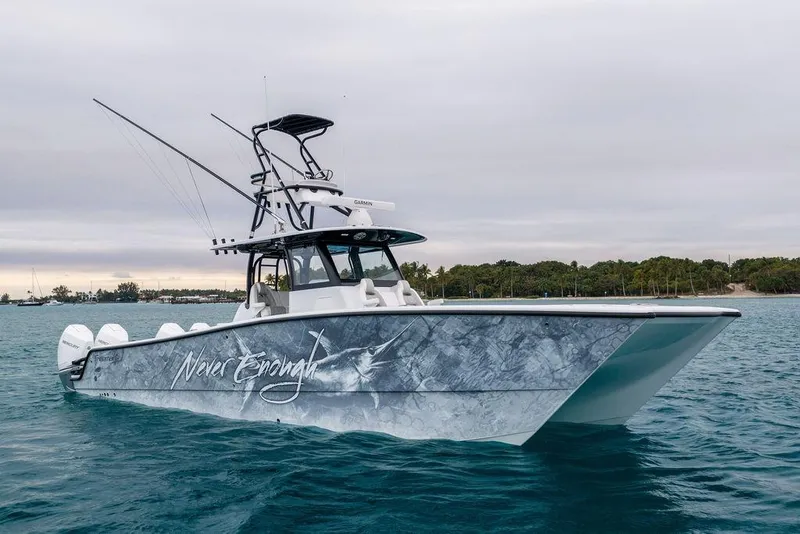 Slide: The Image of 2025 Freeman 38 boat "Never Enough" on water, featuring sleek design and multiple engines. - 3