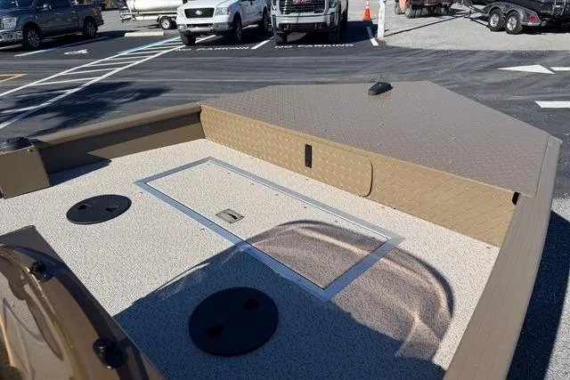 Slide: The Image of 2026 Smoker Craft Pro Sportsman 1660 boat deck with storage compartments in a parking lot. - 7