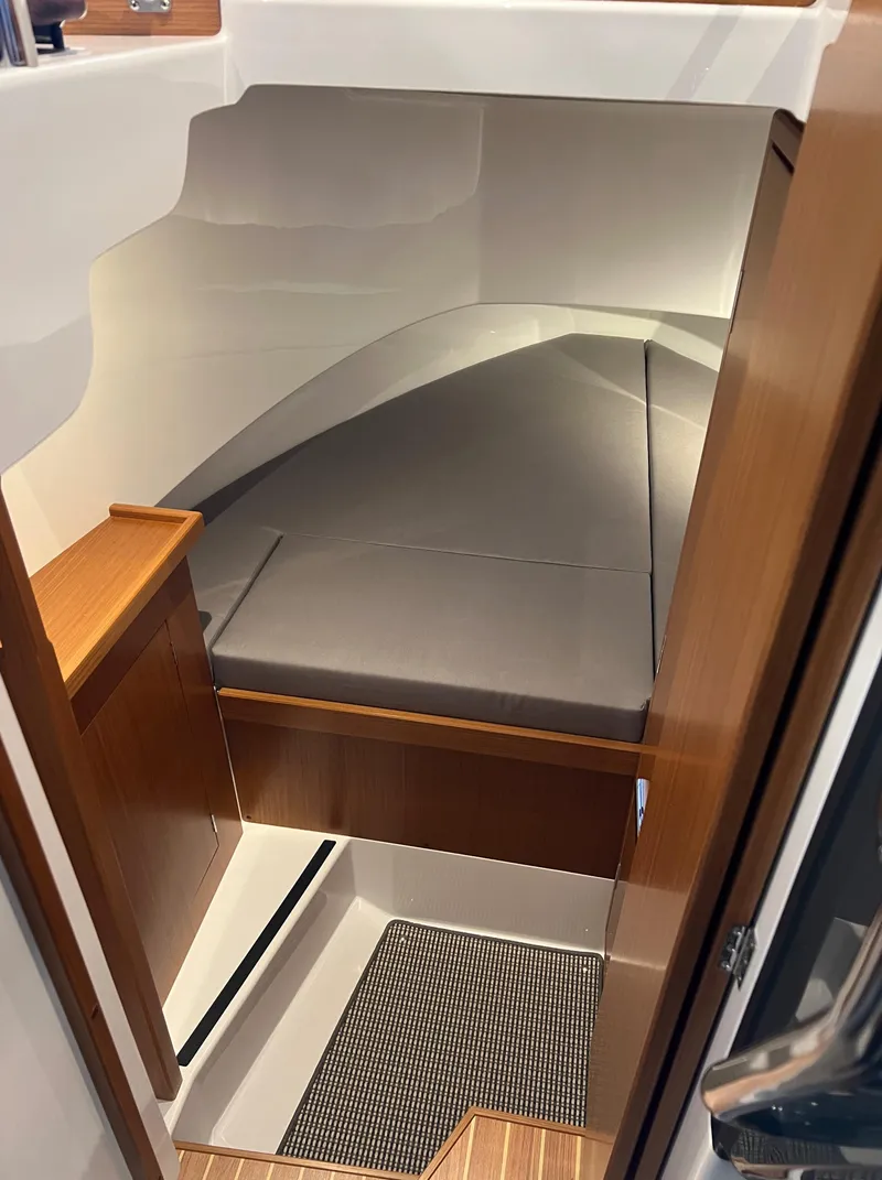 Slide: The Image of 2024 Sargo 28 cabin interior with wooden finishes and cushioned bed. - 18
