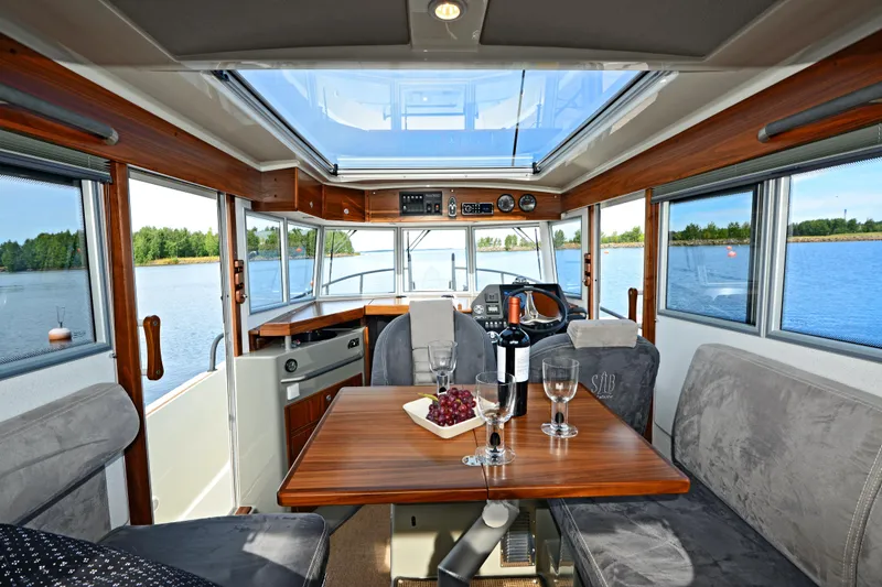 Slide: The Image of Interior of 2024 Sargo 28 boat with dining table, wine, and panoramic windows. - 32
