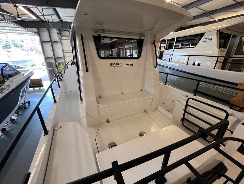 Slide: The Image of 2024 Sargo 28 boat interior, showcasing seating and deck area in a showroom. - 7