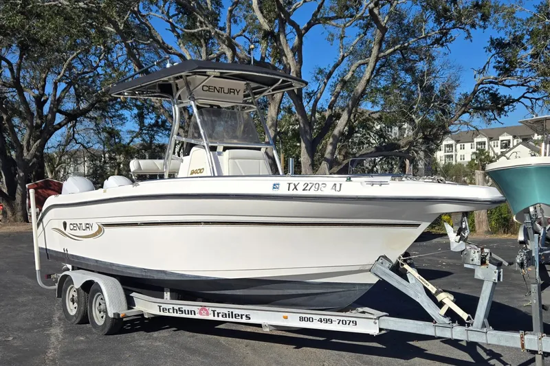 The Image of 2006 Century 2400 Center Console boat on trailer, parked outdoors. - 1