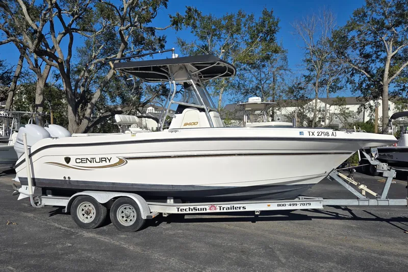 Slide: The Image of 2006 Century 2400 Center Console boat on trailer, parked outdoors. - 2