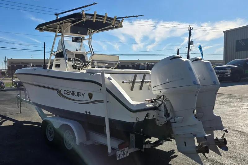 Slide: The Image of 2006 Century 2400 Center Console boat on trailer, dual outboard engines, sunny day. - 5